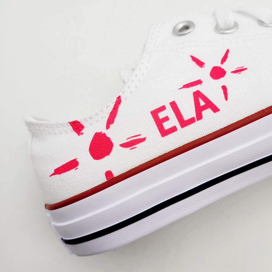 Le grand soleil de l'association ELA et son logo sur une paire de Converse