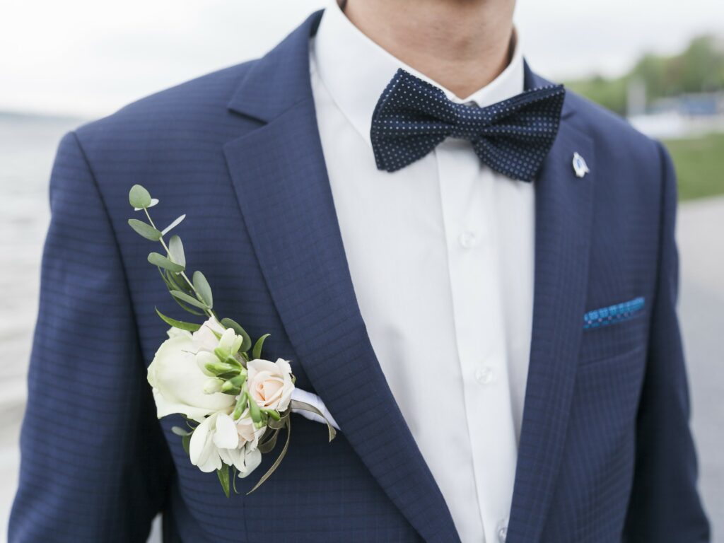 Le nœud papillon ou la pochette peut ajouter une touche qui rappelle la tenue du marié