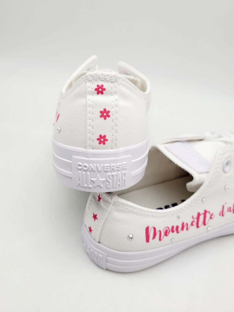 Multiple flower-shaped designs on the back of the Converse sneakers